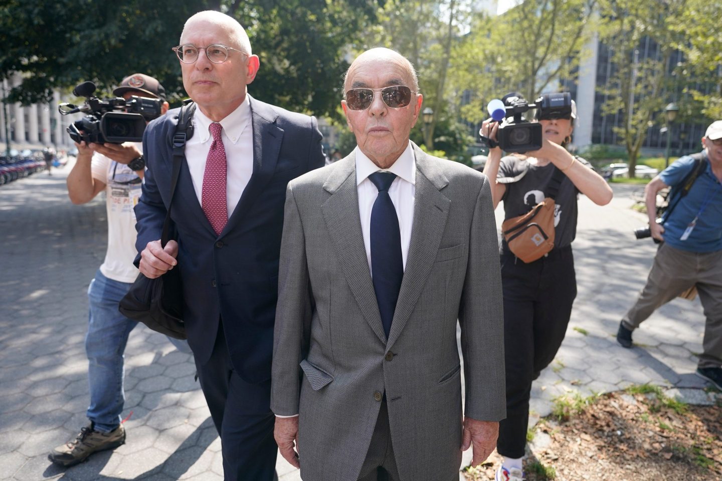 British billionaire Joe Lewis leaves, center, Manhattan federal court, July 26, 2023, in New York.