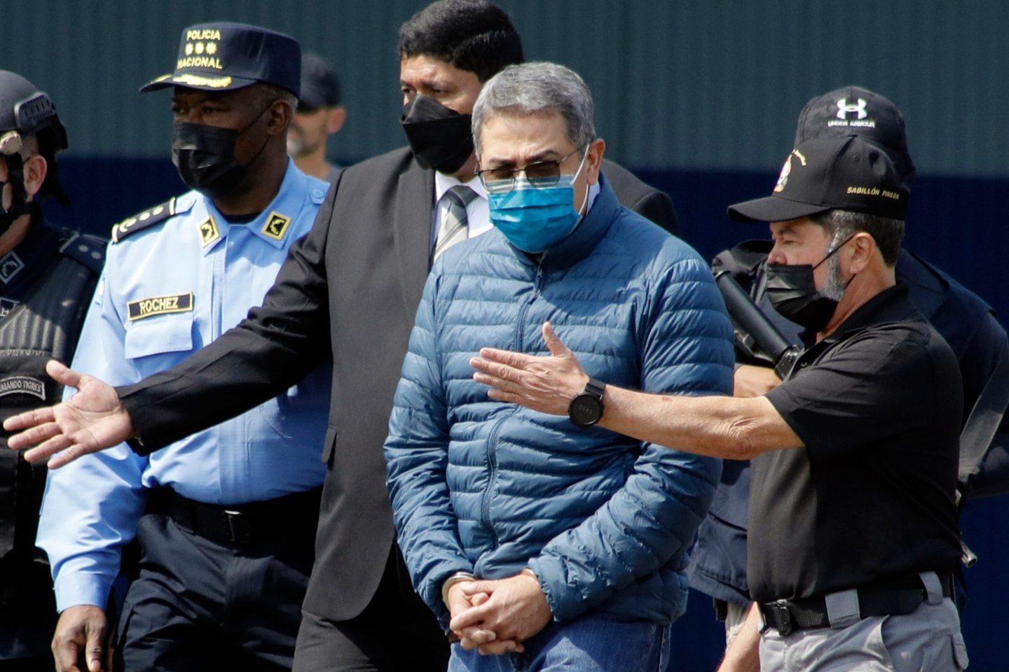 FILE - Former Honduran President Juan Orlando Hernandez, second from right, is taken in handcuffs to a waiting aircraft as he is extradited to the United States, at an Air Force base in Tegucigalpa, Honduras, April 21, 2022. (AP Photo/Elmer Martinez, File)