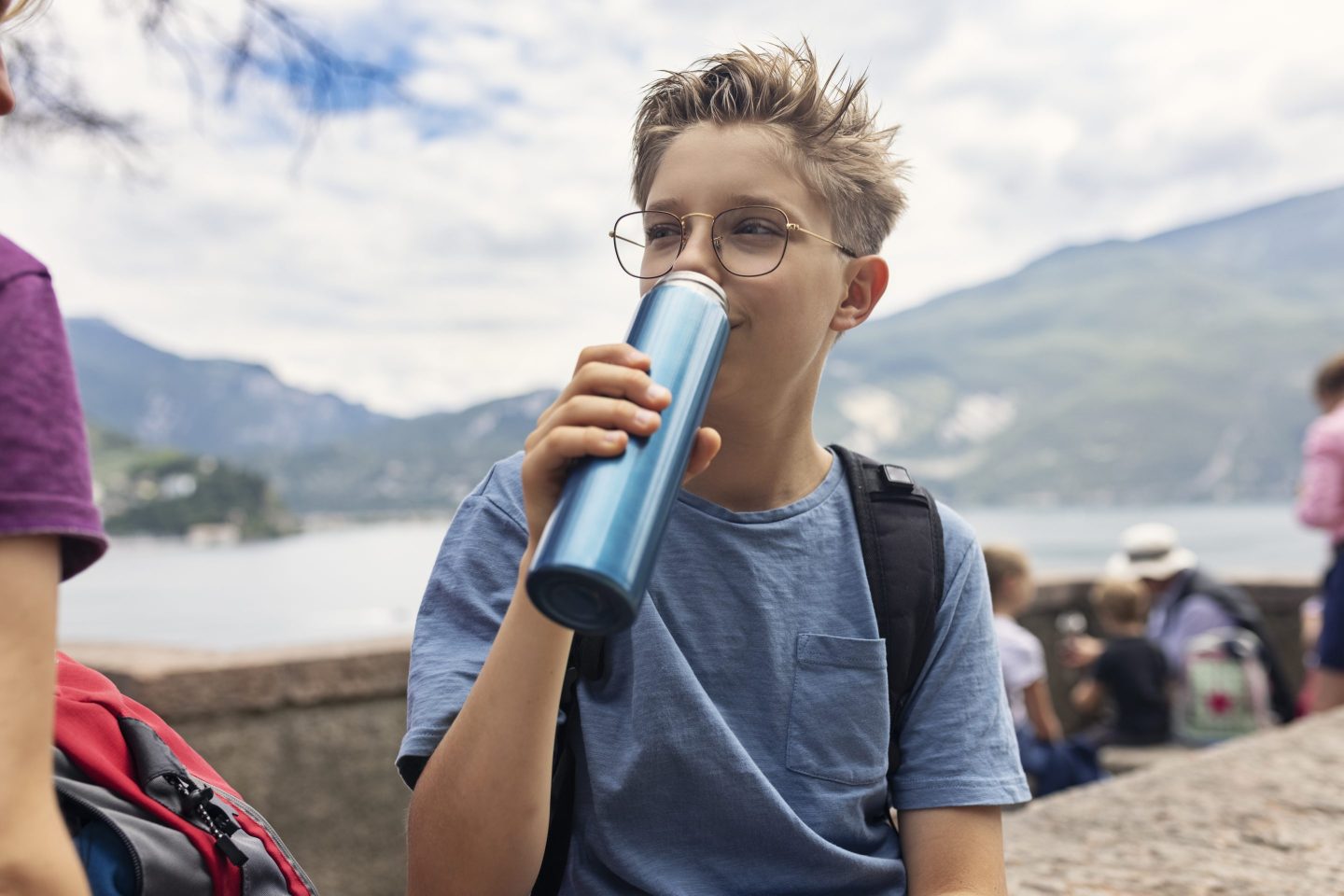 Young hiker drinking from reusable water bottle
