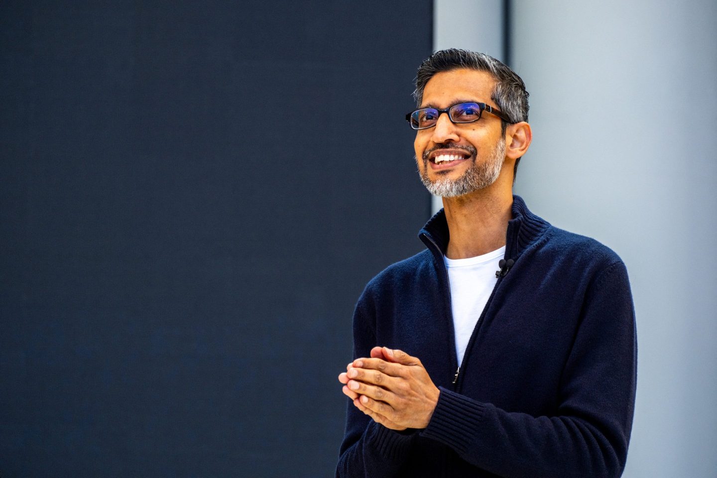 Sundar Pichai holds his hands together and smiles