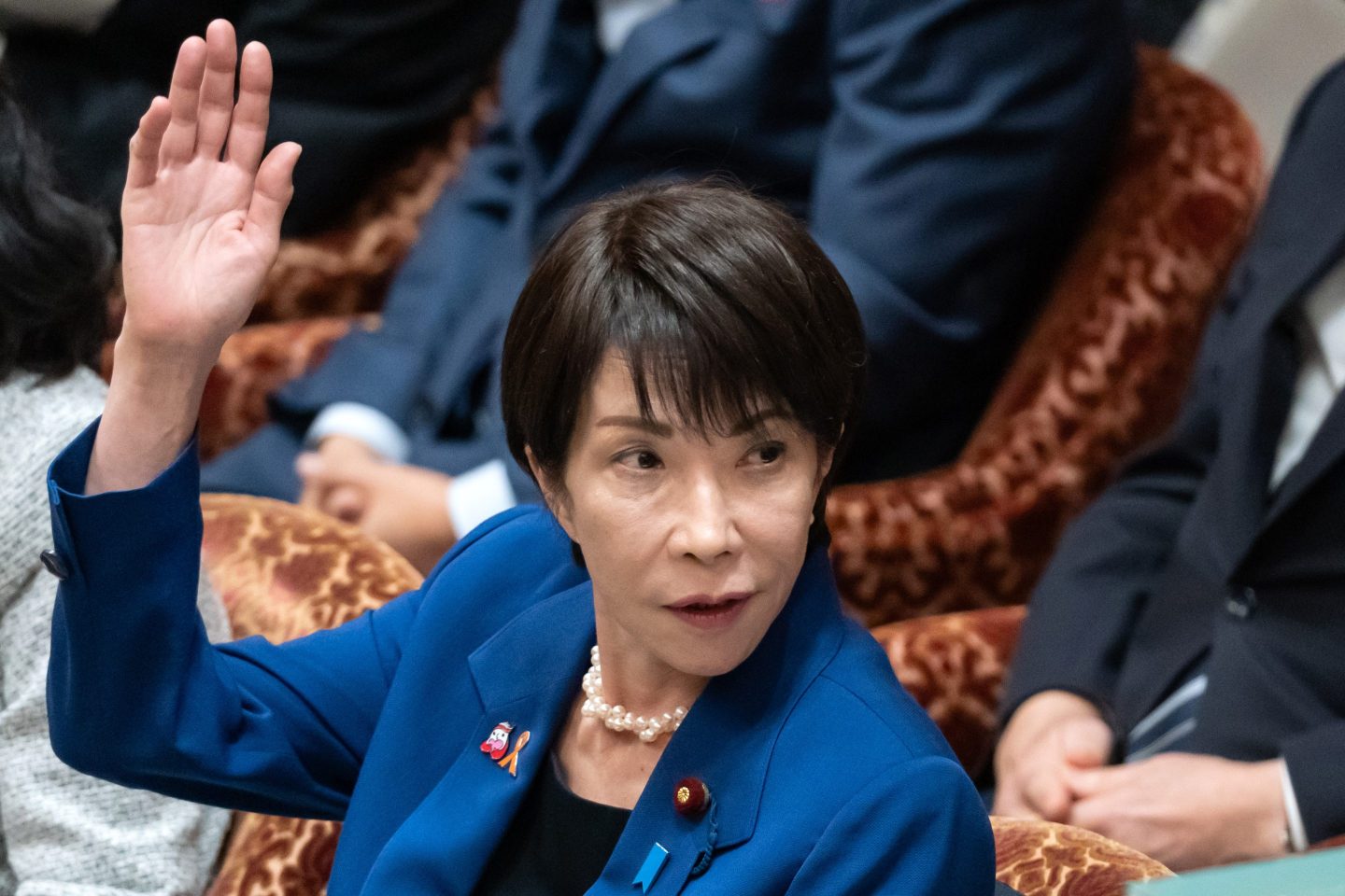 Japanese Prime Minister Sanae Takaichi raises her hand