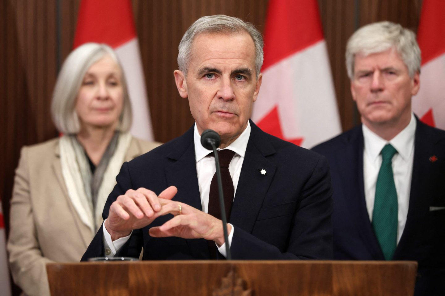 Canadian Prime Minister Mark Carney stands and speaks at a podium